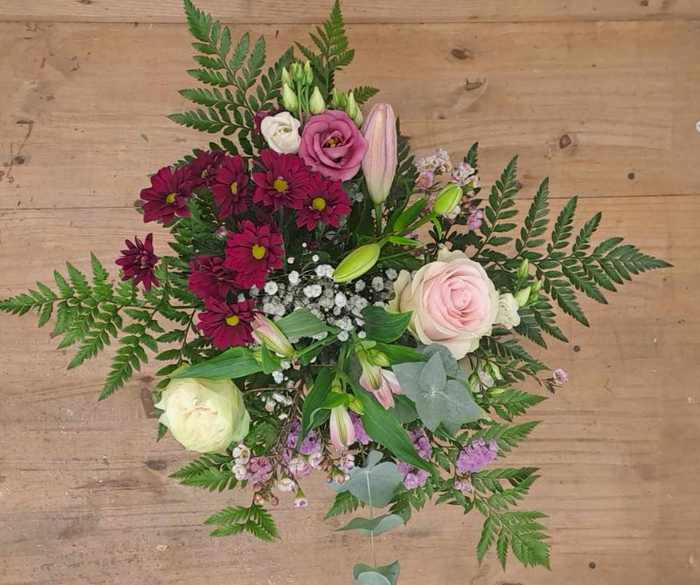 Bouquet rond de roses roses, chrysanthèmes bordeaux et lys, création du fleuriste Au Delà des Fleurs