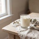 Bougie parfumée artisanale dans un verre, posée sur une table