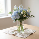 Bouquet de naissance garçon, hortensia et delphinium bleus dans un vase en verre