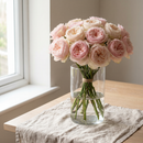Brassée généreuse de roses rose pâle dans un vase en verre